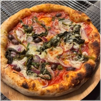 Tomatensaus, basilicum, kappertjes, rode ui, olijven, friarielli (raapstelenblad gebakken met knoflook), geitenkaas, Parmigiano Reggiano (24 maanden gerijpt) en rucola